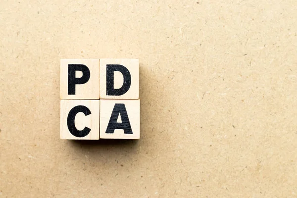 Alfabeto letra bloque en la palabra PDCA (abreviatura comercial de plan do check act) sobre fondo de madera — Foto de Stock