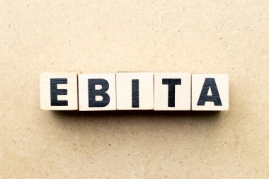 Ahşap arka planda Ebita kelimesindeki alfabe harf bloğu (faiz, vergi ve amortisman öncesi kazancın kısaltması)