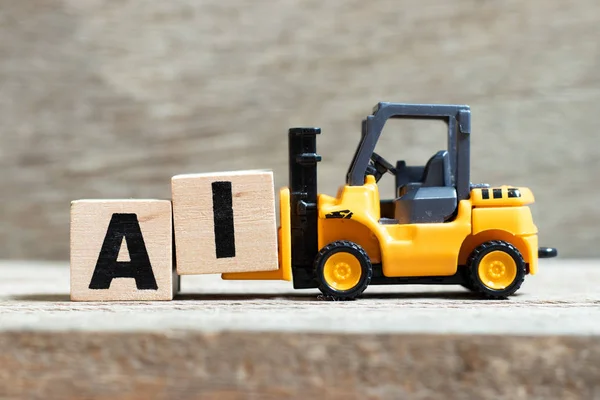 玩具叉车举行字母块i完成字Ai（页面人工智能的缩写）在木材背景 — 图库照片