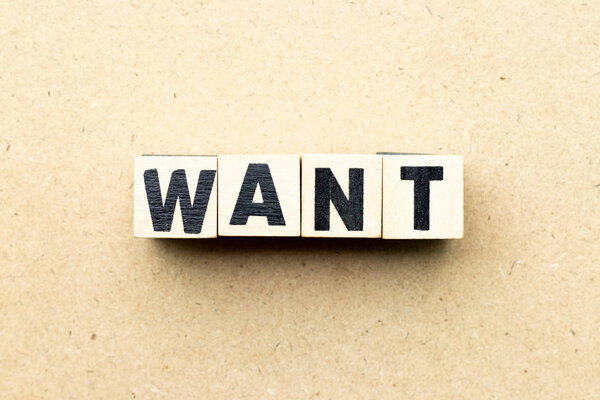 Буквенный блок в слове хотят на деревянном фоне
