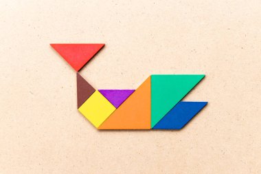 Ahşap arka planda balina şeklinde renk tangram bulmaca