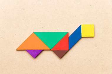 Ahşap arka planda kaplumbağa, terrapin veya kaplumbağa şeklinde renkli tangram bulmaca