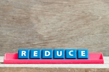 Kelime ahşap arka plan üzerinde azaltmak kırmızı raf üzerinde Kiremit harfi