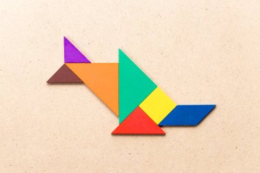 Şeklinde balık (balık ya da boynuzlu balina) ahşap arka plan üzerinde renkli tangram