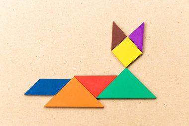 Renk tangram bulmacanın kedi şekil üzerinde ahşap arka plan aşağı yalan