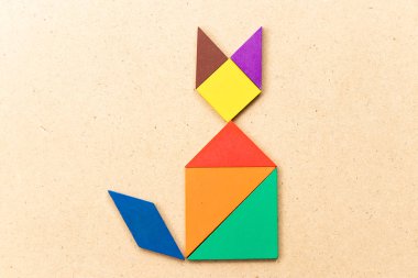 Ahşap arka plan üzerinde kedi şekil defada renk tangram bulmacanın