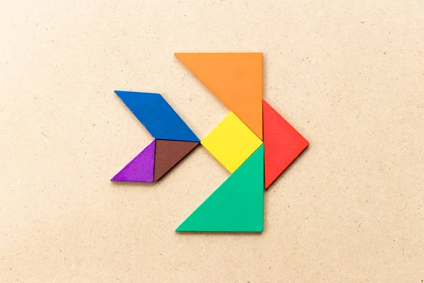 Ahşap zemin üzerinde balık şeklinde renkli tangram yapbozu