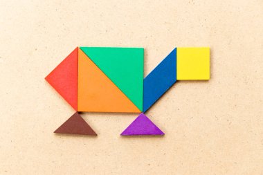 Ahşap arka planda kaplumbağa, terrapin veya kaplumbağa şeklinde renkli tangram bulmaca