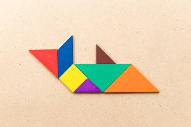 Ahşap zemin üzerinde köpekbalığı ya da balina şeklinde renk tangramı yapbozu