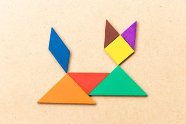 Renk tangram bulmacanın kedi şekil üzerinde ahşap arka plan aşağı yalan