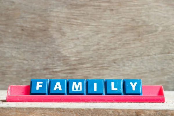 Fliese Buchstabe auf rotem Regal in Wort Familie auf Holz Hintergrund — Stockfoto