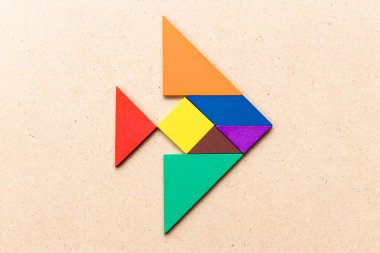 Ahşap zemin üzerinde balık şeklinde renkli tangram yapbozu