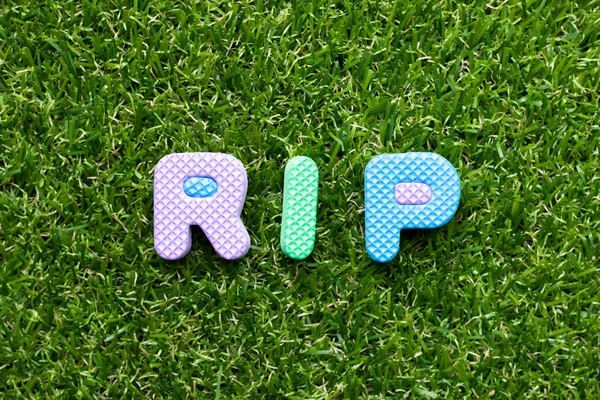 Letra de espuma de juguete en la palabra RIP (abreviatura de descanso en paz) sobre fondo de hierba verde —  Fotos de Stock