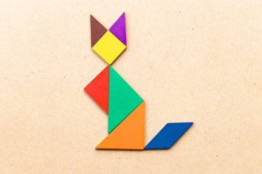 Ahşap arka plan üzerinde kedi şekil defada renk tangram bulmacanın