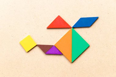 Ahşap arka planda helikopter veya helikopter şeklinde renk tangram bulmaca