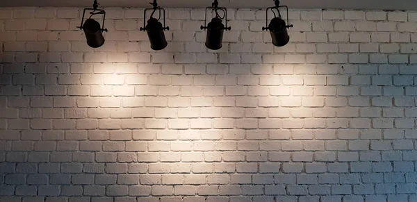 Hängescheinwerfer beleuchten weißen Backsteinwand Hintergrund mit Kopierraum — Stockfoto