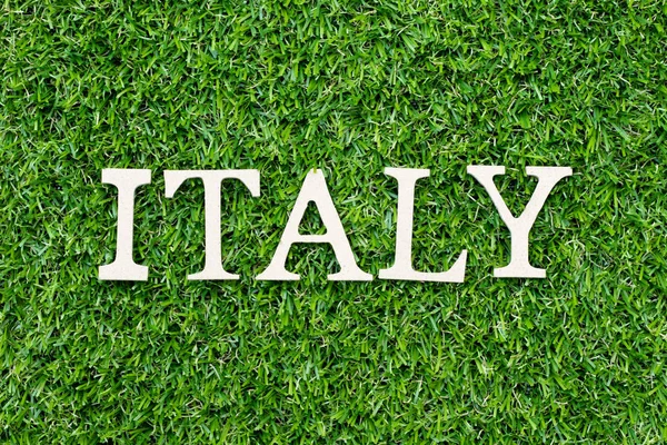 Legno alfabeto lettera in parola italia su sfondo erba verde — Foto Stock