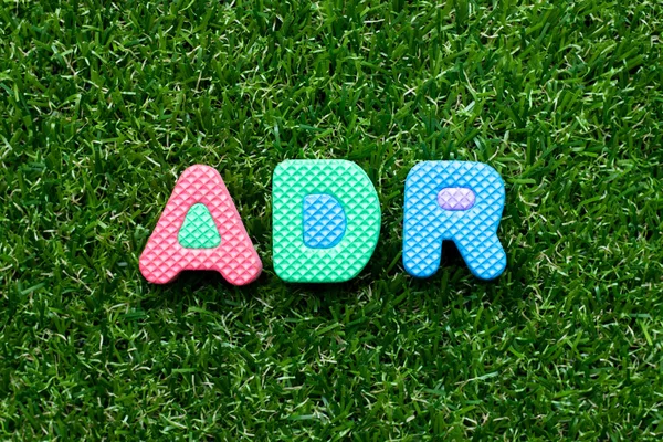 Spielzeugschaum Buchstabe in Wort adr (Abkürzung für unerwünschte Medikamentenreaktion) auf grünem Gras Hintergrund — Stockfoto