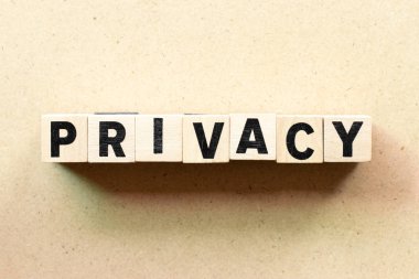 Ahşap arka planda kelime gizliliğinde harf bloğu