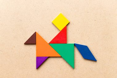 Ahşap arka planda at şekli şeklinde adam binmek renk tangram bulmaca