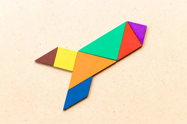 Farb-Tangram-Puzzle in Raketen- oder Raketenform auf Holz-Hintergrund (Konzept für neue Erfahrungen, Start-up-Projekt) — Stockfoto