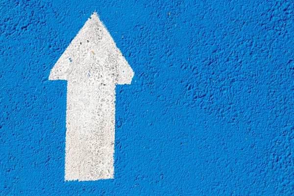 İleri yönde ok simgesi mavi beton yol arka plan üzerinde beyaz resim