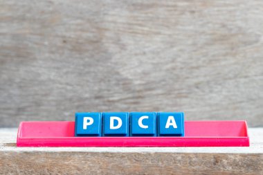 Kelime Pdca kırmızı raf üzerinde kiremit harfi (plan iş kısaltması kontrol hareket yapmak) ahşap arka plan