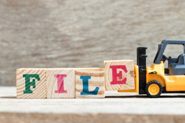 Oyuncak forklift ahşap arka plan üzerinde word dosyasındaki blok e harfi tutun