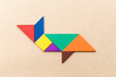 Ahşap zemin üzerinde köpekbalığı ya da balina şeklinde renk tangramı yapbozu