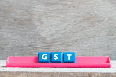 Ahşap arka planda gst (Mal ve Hizmet Vergisi Kısaltması) kelimesinde kırmızı raf üzerine kiremit harfi