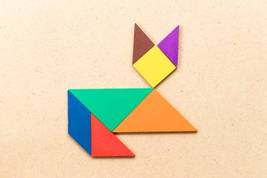 Renk tangram bulmacanın kedi şekil üzerinde ahşap arka plan aşağı yalan