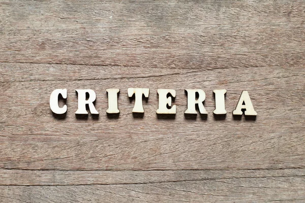 Bloque de letras en los criterios de palabras sobre fondo de madera — Foto de Stock