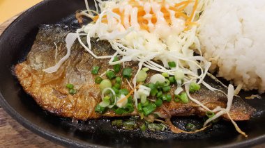 Dilimlenmiş saba uskumrusu, salata ve pirinç arkaplanlı.