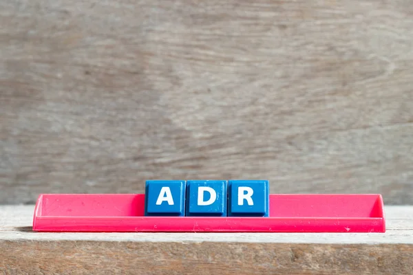 Fliesenbuchstabe auf rotem Gestell in Wort adr (Abkürzung für unerwünschte Medikamentenreaktion) auf Holzgrund — Stockfoto