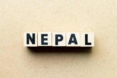 Ahşap arka planda kelime Nepal harf bloğu