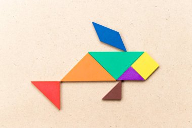 Ahşap zemin üzerinde balık şeklinde renkli tangram yapbozu