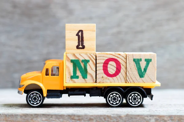 Lastbil hålla bokstav block i ord 1nov på trä bakgrund (Koncept för datum 1 månad November) — Stockfoto
