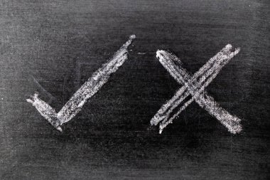 Beyaz renk tebeşir el kara tahta arka plan üzerinde onay işareti doğru ve yanlış şeklinin çizimi