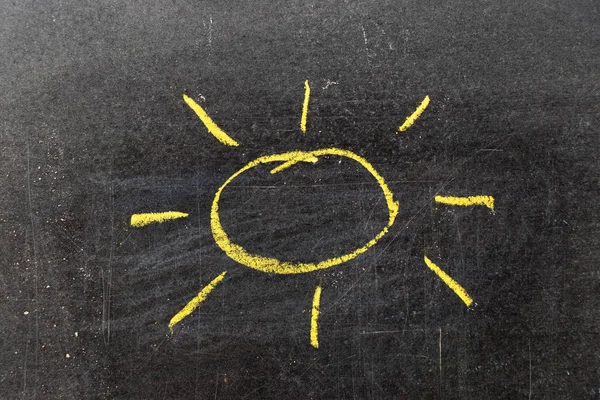 Yellow color chalk hand drawing in sun with ray shape on blackboard background — Stock Photo, Image