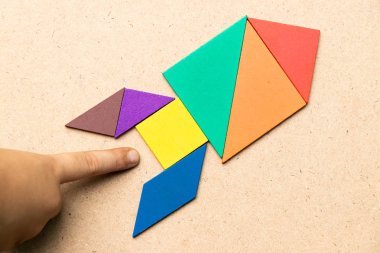 Ahşap arka plan (Konsept başlangıç, yeni bir deneyim ya da iş için üste de el ile roket şeklinde renk tangram)