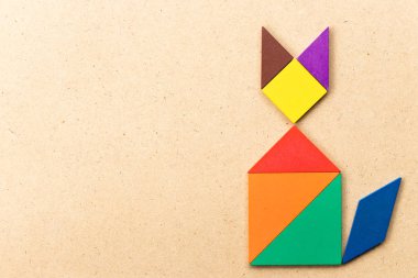 Ahşap arka plan üzerinde kedi şekil defada renk tangram bulmacanın