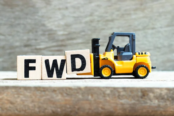 Toy heftruck Hold letter blok D om Word FWD (afkorting van forward) op de hout achtergrond te voltooien — Stockfoto