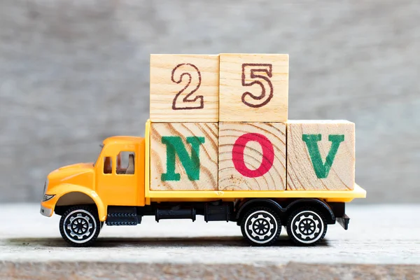 LKW halten Buchstabenblock in Wort 25nov auf Holz Hintergrund (Konzept für Datum 25 Monat November) — Stockfoto