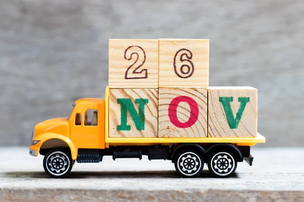 LKW halten Buchstabenblock in Wort 26nov auf Holz Hintergrund (Konzept für Datum 26 Monat November) — Stockfoto