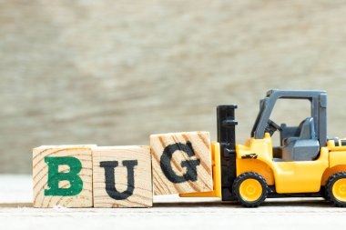 Oyuncak forklift tahta arkaplan üzerindeki kelime hatasını tamamlamak için G harfi blok tutun