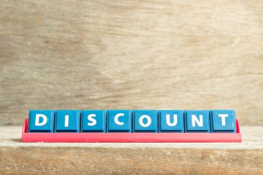 Ahşap zemin üzerinde kelime indirimiyle kırmızı raftaki döşeme harfi