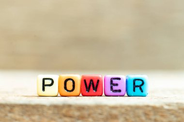 Ahşap arka planda siyah harfli renkli boncuk.