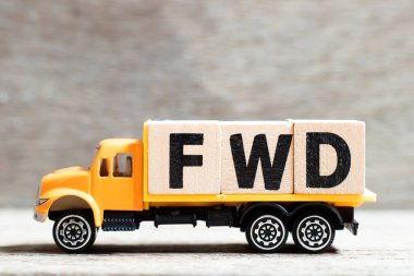Truck hold letter block in word FWD (Abbreviation of forward) on wood background clipart