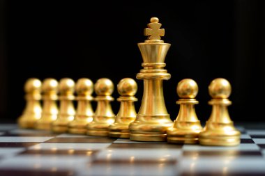 Siyah arkaplanda piyon olan altın kral satranç taşı standı (takım çalışması kavramı, yönetim)