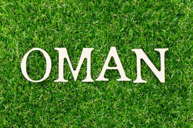 Ahşap harfler yeşil çimenli arka planda.